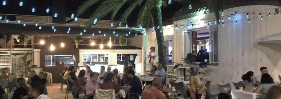 Lively outdoor dining atmosphere at night in restaurant Nostrissima.